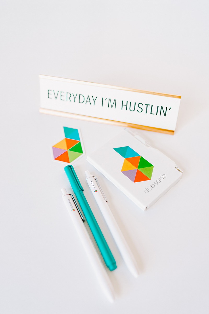 Pens and business cards for Dubsado with a sign that says "Everyday I'm Hustlin'" Dubsado is one of the best tools for your photography business